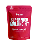 Red package labeled blume Superfood Mulling Kit, containing mulling spice mix with organic spices and orange slices. Package features a simple, bold font and indicates the product is caffeine-free and vegan.